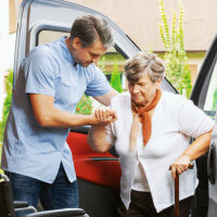man assisting the senior woman to walk