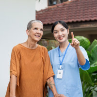 aide and senior woman walking together