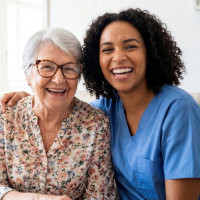 aide and senior woman smiling