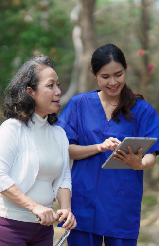 aide and senior woman walking together