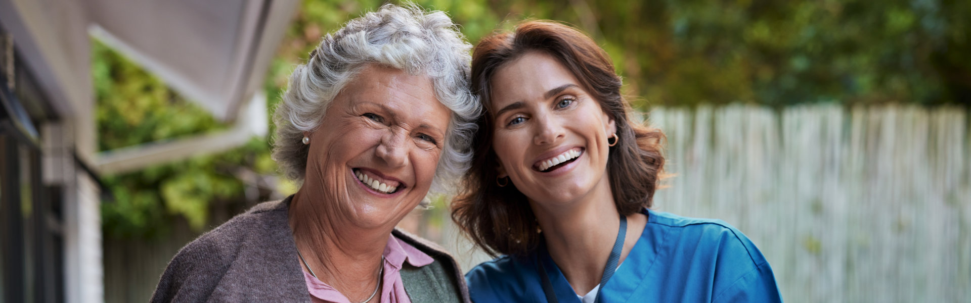 senior woman and aide smiling together