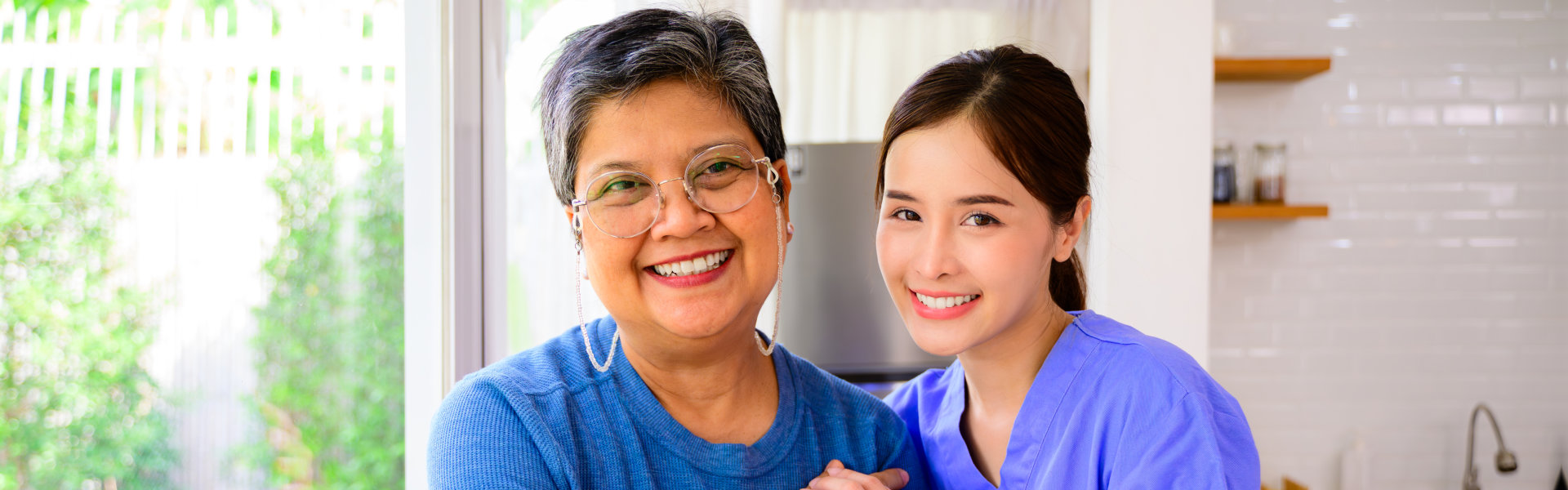aide and senior woman smiling together