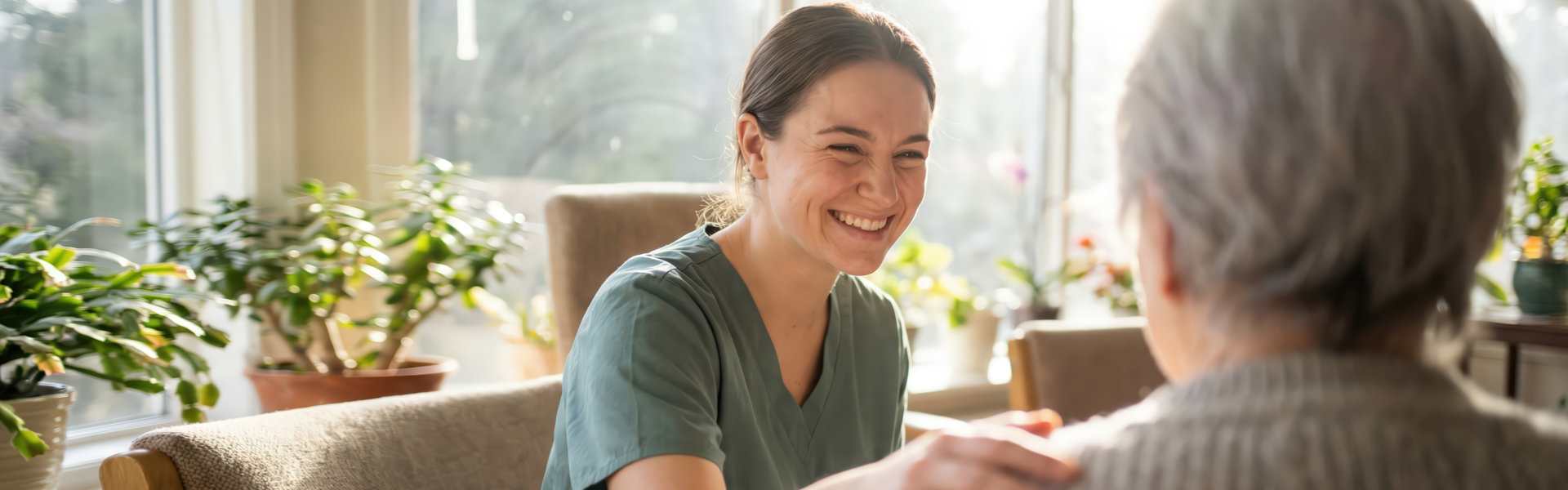 caregiver smiling and comforting elderly woman